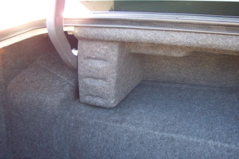 2001 Ford Crown Victoria - The interior of a car's trunk shows gray carpeting and a custom-fitted enclosure.