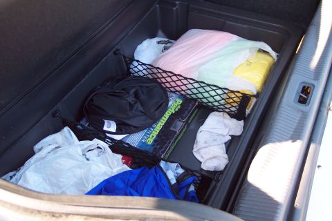 2001 Ford Crown Victoria - The trunk of a car contains various items including plastic bags filled with colorful objects and a performance air filter box.