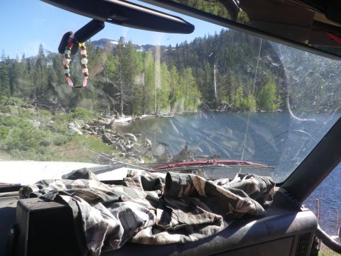 1991 Ford Bronco - The view from inside a vehicle shows a lake surrounded by trees and mountains.