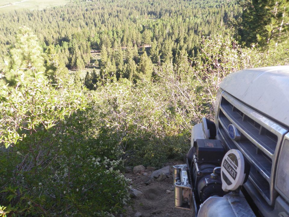 Silver 1991 Ford Bronco front with winch and halogen lights on a wooded trail