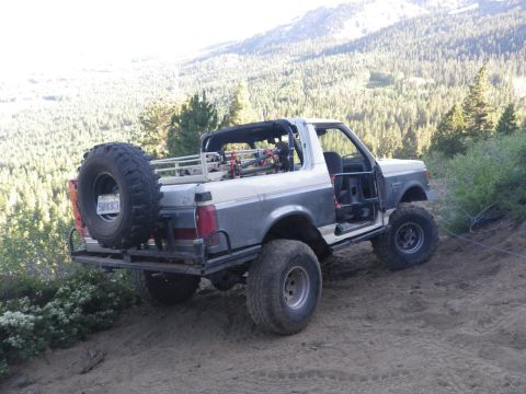 1991 Ford Bronco - This modified 1991 Ford Bronco is seen from the rear, equipped for off-road adventures with a large spare tire and roll cage.