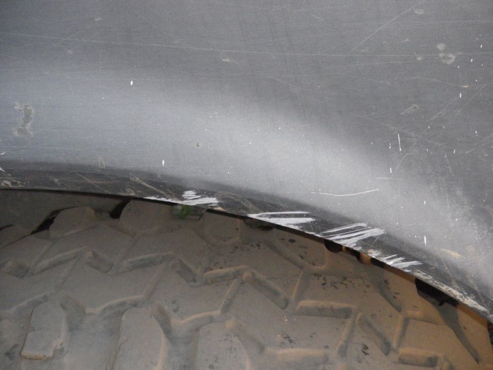 Close-up of a tire tread and the inside of a vehicle's wheel well