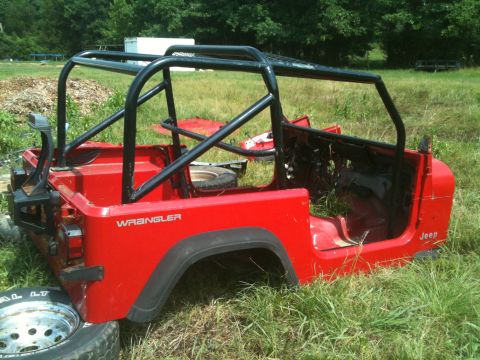 1992 Jeep YJ - This 1992 Jeep YJ tub and roll cage is sitting in a grassy field.