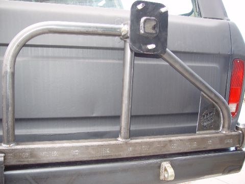 1978 Ford Bronco - Custom rear bumper and roll cage assembly with a spare tire mount is installed on a dark-colored vehicle.