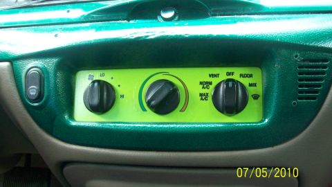 2004 Ford Crown Victoria - Interior view of a green dashboard climate control knobs and vent settings.