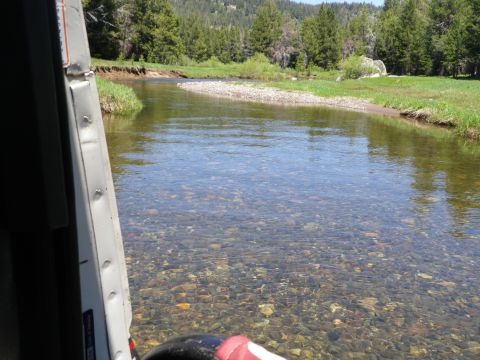 1991 Ford Bronco - A scenic view of a river flowing through a meadow with trees in the background.