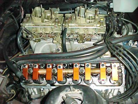 1968 Mercury Cougar - Close-up view of a V8 engine dual carburetors and prominent orange valve train components.