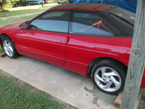 1994 Ford Probe - Side view of a red 1994 Ford Probe coupe parked outdoors.