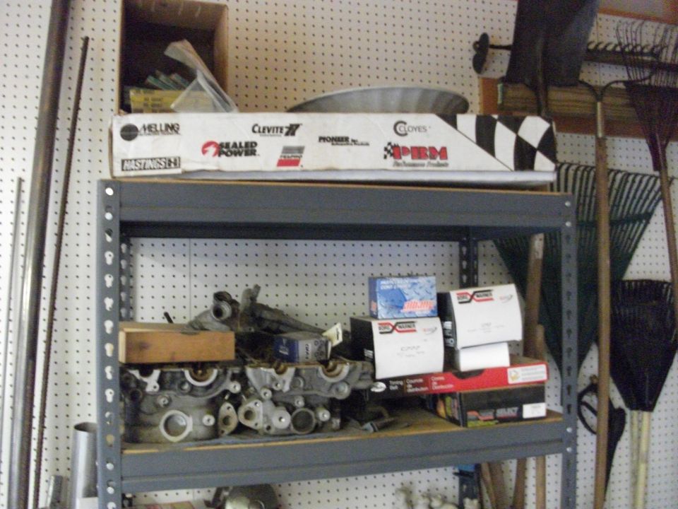 Garage shelf with aluminum cylinder heads and boxed engine rebuild parts