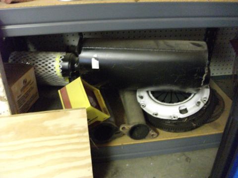 1994 Ford Probe - Various automotive parts, including a muffler and clutch, are neatly organized on a shelf.