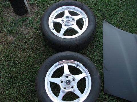 1994 Ford Probe - Two chrome five-spoke wheels and a dark hood are shown on the grass.