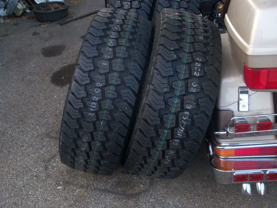 Tires next to a motorcycle's rear section with chrome accents and red lights
