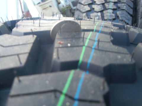1989 Ford Bronco - A tire tread is shown up close, with a coin placed on it to indicate its size.