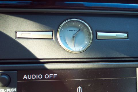 2001 Ford Crown Victoria - The interior of a Lincoln features a prominent analog clock and audio controls.