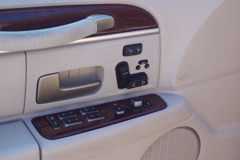 2001 Ford Crown Victoria - The interior door panel shows wood trim and controls for power windows and seats, indicative of a luxury sedan.