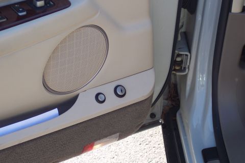 2001 Ford Crown Victoria - Close-up of a car's interior door panel, showing a speaker and lock mechanisms.