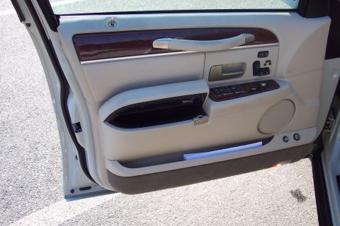 2001 Ford Crown Victoria - The interior of a car door panel with wood trim and beige upholstery is visible.