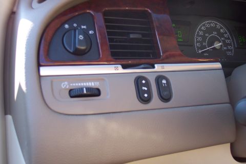 2001 Ford Crown Victoria - Interior view of a car's dashboard, wood grain accents and various control buttons.
