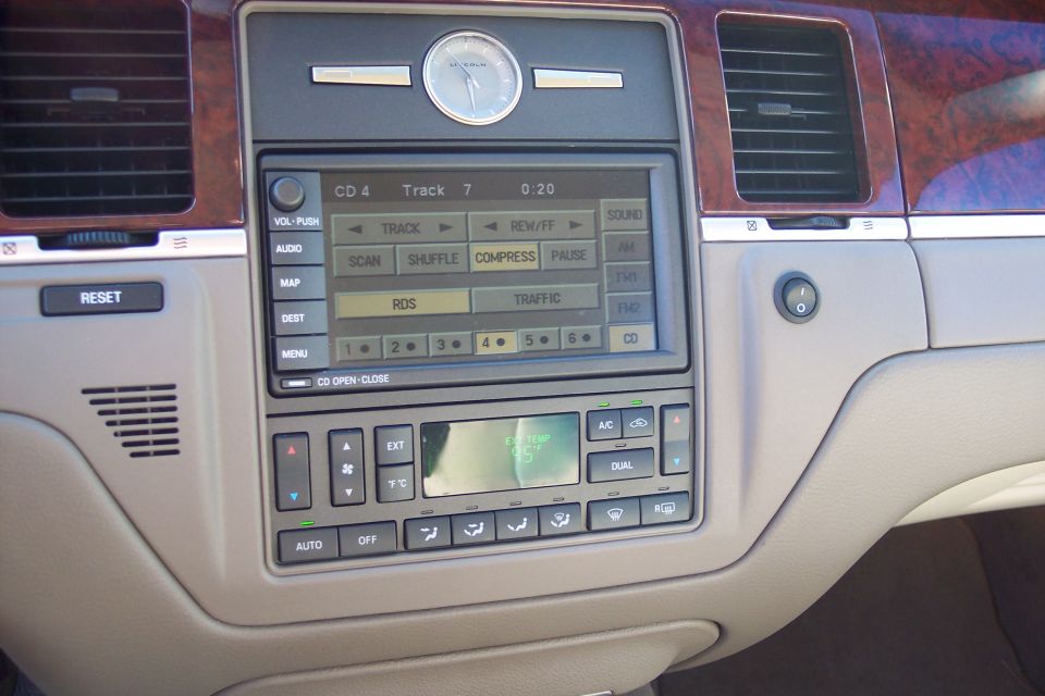 Interior dashboard of a Lincoln Town Car showing infotainment screen and climate controls