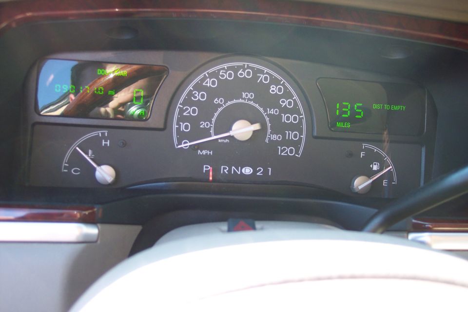 Dashboard gauges of a 2004 Lincoln Town Car, showing 135 miles to empty and a temperature gauge