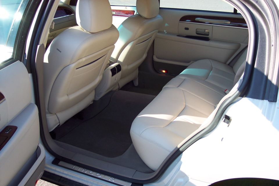 White Lincoln Town Car interior with beige leather seats, rear passenger view