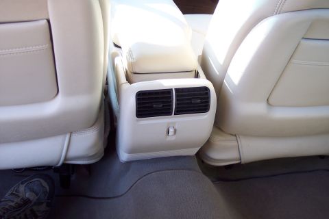 2001 Ford Crown Victoria - Interior view of rear seat air vents and cream leather upholstery.