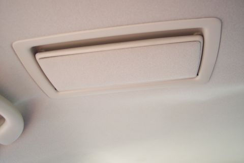 2001 Ford Crown Victoria - A close-up view of a vehicle's interior ceiling vent, showing its beige trim and textured headliner.