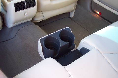 2001 Ford Crown Victoria - Interior view of a vehicle's rear seat area, a dual cup holder and climate controls.