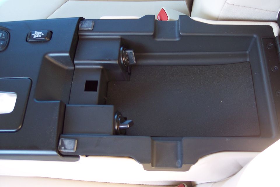 Center console storage compartment with a button labeled 'OFF ROAD' and two 12V power outlets