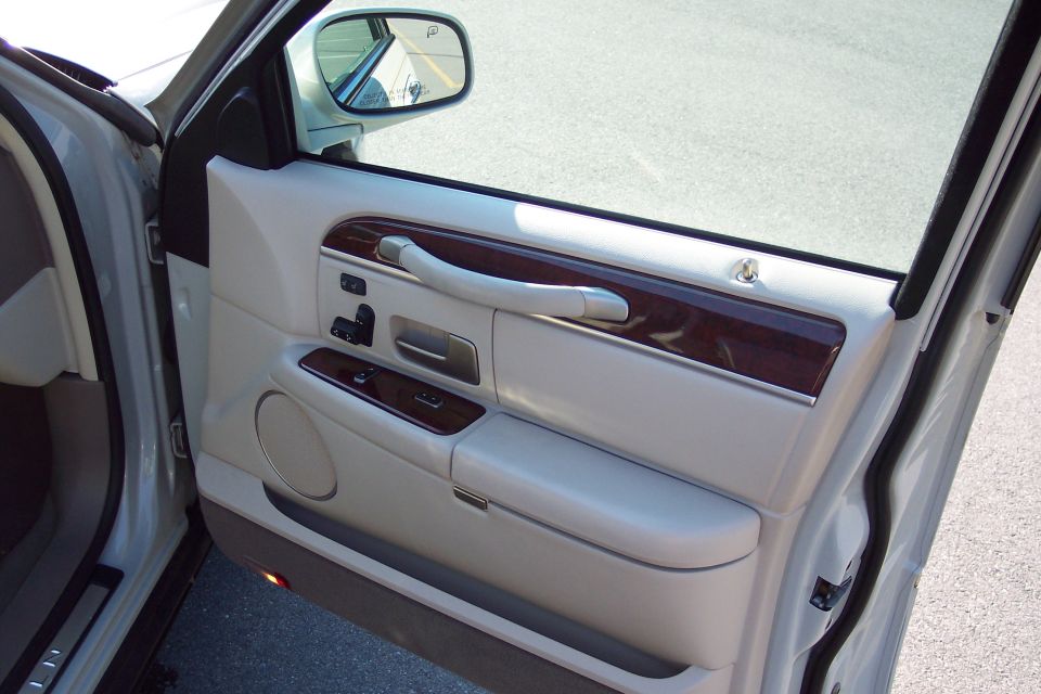 Interior door panel with wood trim and tan leather