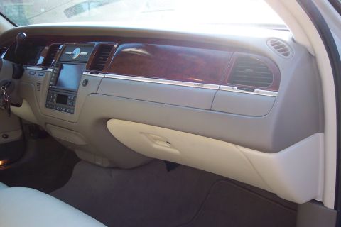 2001 Ford Crown Victoria - The interior of a luxury sedan features a wood-trimmed dashboard with a central infotainment screen and air vents.