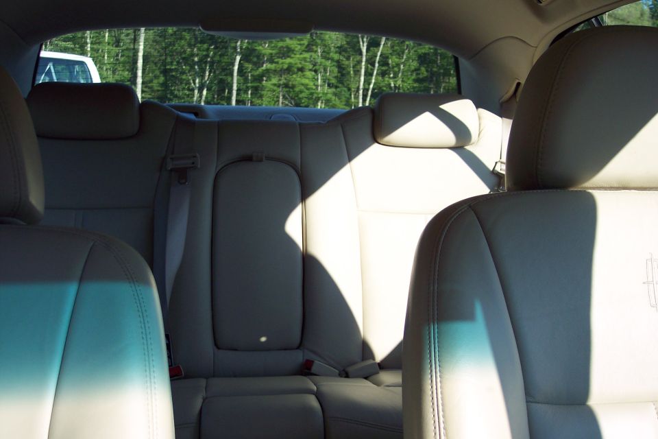 Interior rear seats of a car, light-colored leather upholstery