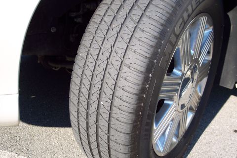2001 Ford Crown Victoria - A close-up view of a tire and wheel assembly on a white vehicle.