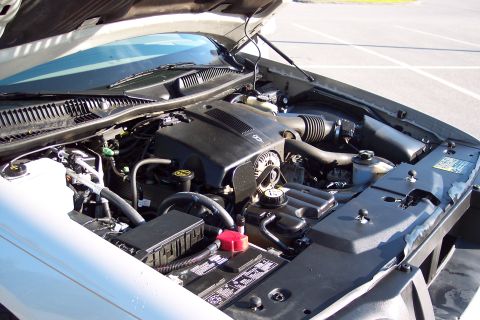 2001 Ford Crown Victoria - The engine compartment is visible with the hood raised, revealing the motor and associated parts.