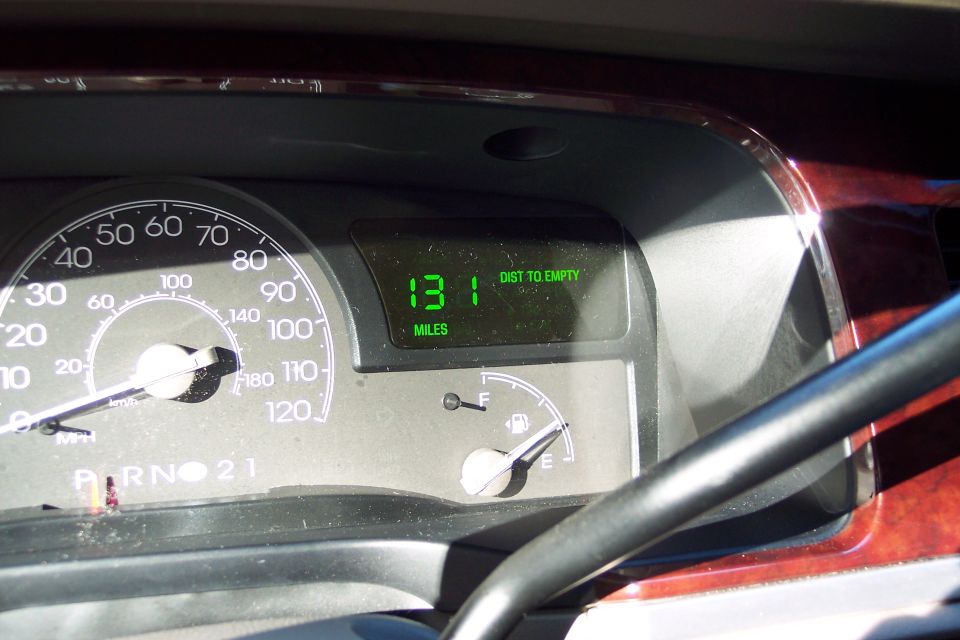 Dashboard of a 2004 Lincoln Town Car showing a speedometer, fuel gauge, and a digital display reading "131 MILES DIST TO EMPTY"