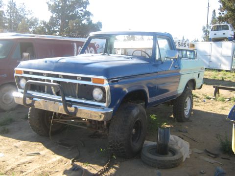 1978 Ford Bronco - This lifted Ford pickup truck features a prominent bull bar and a two-tone paint scheme. The grille suggests a mid-1970s model year.