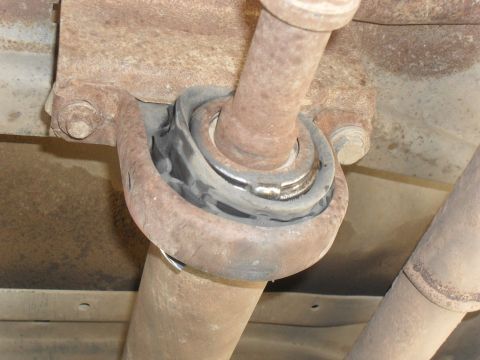 1991 Ford F-350 - The driveshaft carrier bearing mount shows significant rust and wear.