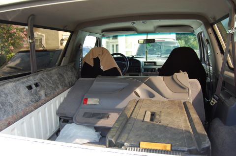 1994 Ford Bronco - The interior of a 1992 Ford Bronco shows disassembled parts and a tan blanket on the driver's seat.