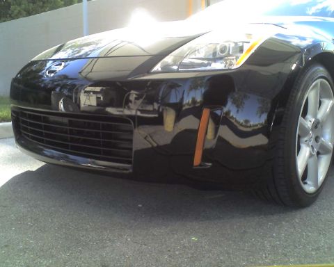 1993 Ford C-350 (Centurion Conversions) - Front view of a black Nissan 350Z showing the bumper, grille, and wheel.
