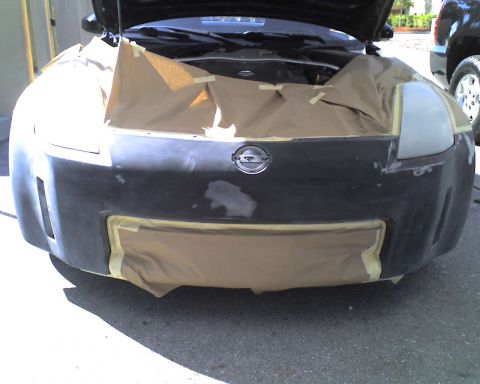 1993 Ford C-350 (Centurion Conversions) - The front of a Nissan 350Z is prepped for repair, with the hood open and the bumper covered.