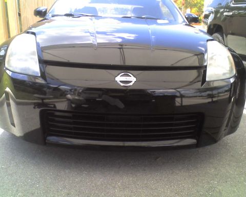 1993 Ford C-350 (Centurion Conversions) - Front view of a black Nissan 350Z with a visible Nissan badge and horizontal grille.