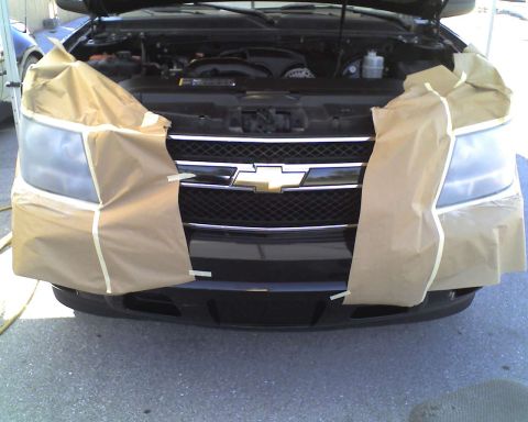 1993 Ford C-350 (Centurion Conversions) - Front view of a black Chevrolet SUV, hood open, with headlights covered for protection.