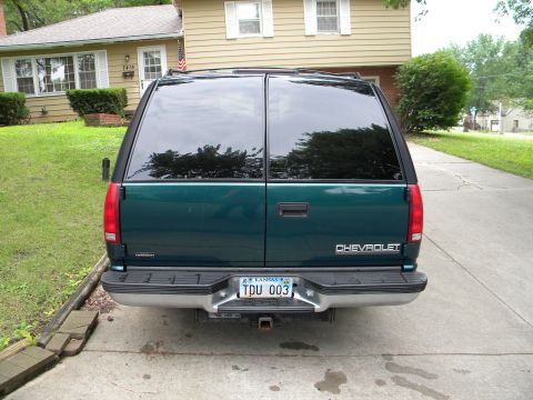 1999 Chevrolet Suburban - Rear view of a dark green 1999 Chevrolet Suburban parked in a driveway.