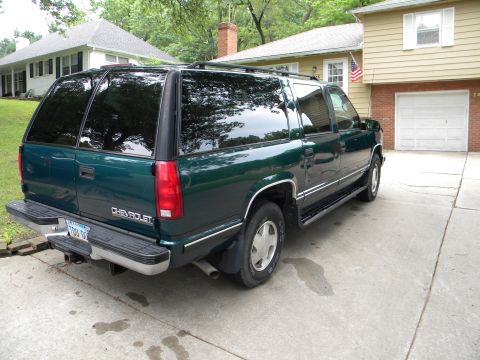 1999 Chevrolet Suburban - Green 1999 Chevrolet Suburban parked in front of a house and garage.