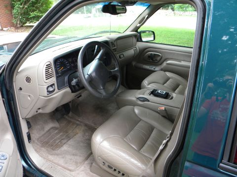 1999 Chevrolet Suburban - The interior of a 1999 Chevrolet Suburban features tan leather seats and a full dashboard view.