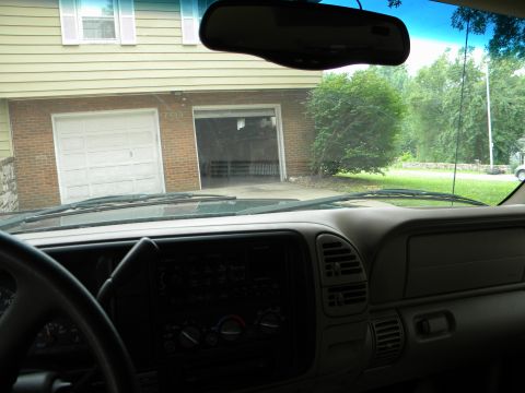 1999 Chevrolet Suburban - Interior view of a 1999 Chevrolet Suburban, looking out through the windshield at a residential garage.