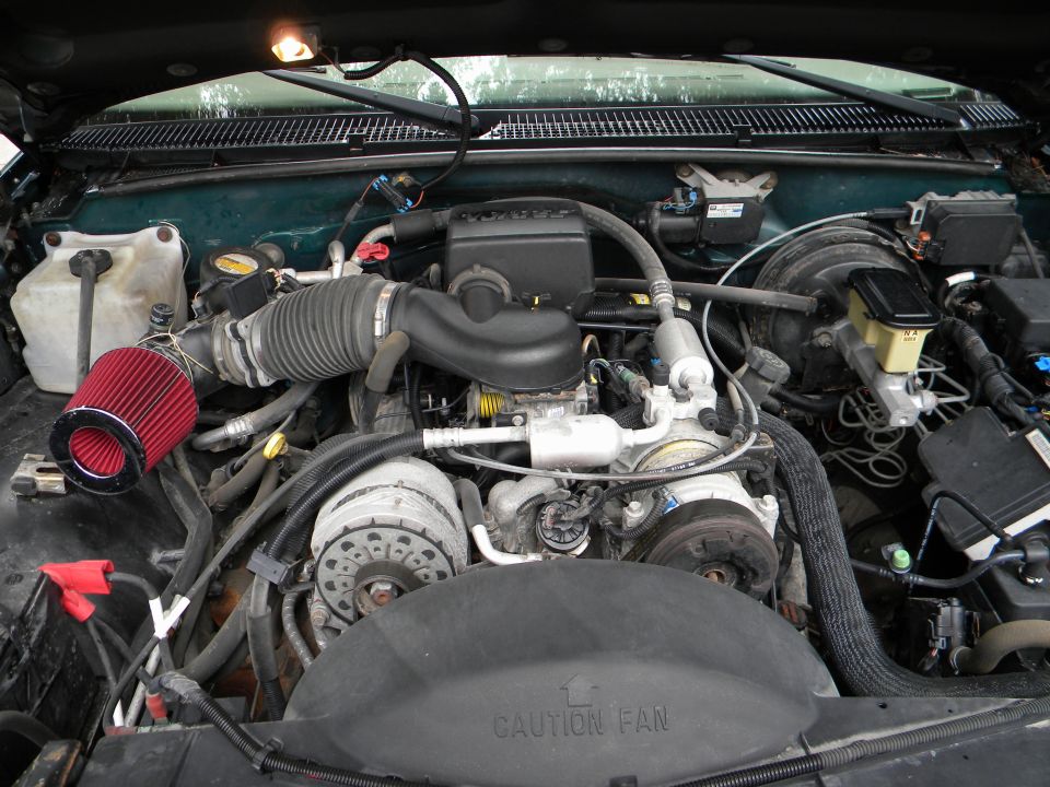 Engine bay with aftermarket air filter and various hoses and components