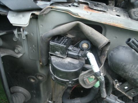 1998 Lincoln Mark VIII - Close-up of an engine component, possibly a fuel pump or sensor, with visible Ford branding and part number F1E10N.
