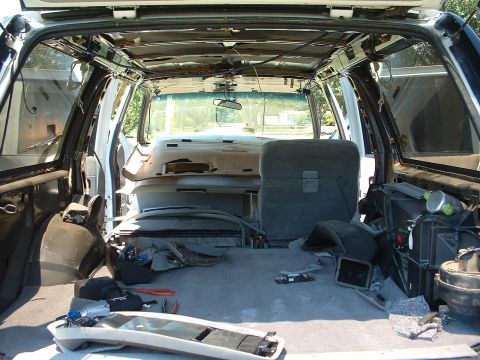 1994 GMC Suburban - The interior of an SUV is shown with its panels removed, revealing the internal structure and wiring.