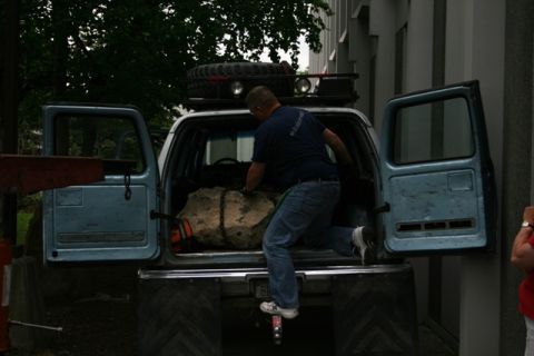 1990 Chevrolet Suburban - A man loads a large object into the back of a light blue 1990 Chevrolet Suburban.